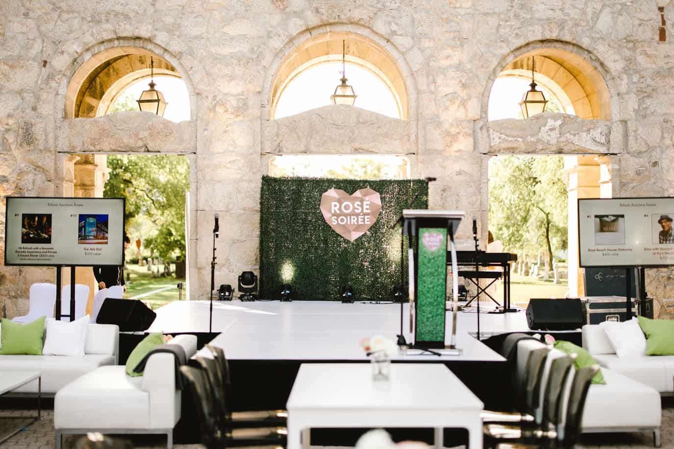 Stunning indoor wedding reception setup at Melanie Parent Events in Winnipeg featuring elegant decor, greenery backdrop, and comfortable seating arrangements.