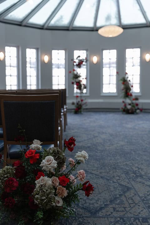 Elegant wedding ceremony setup with floral arrangements inside a beautifully lit venue in Winnipeg.