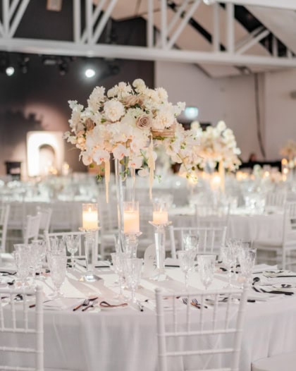 Elegant wedding reception table with white floral centerpieces and candle decorations at Melanie Parent Events in Winnipeg.